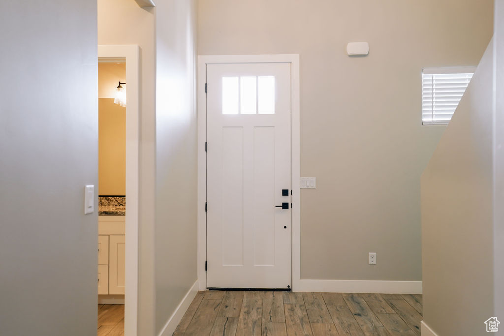 Foyer entrance with light wood-type flooring and baseboards