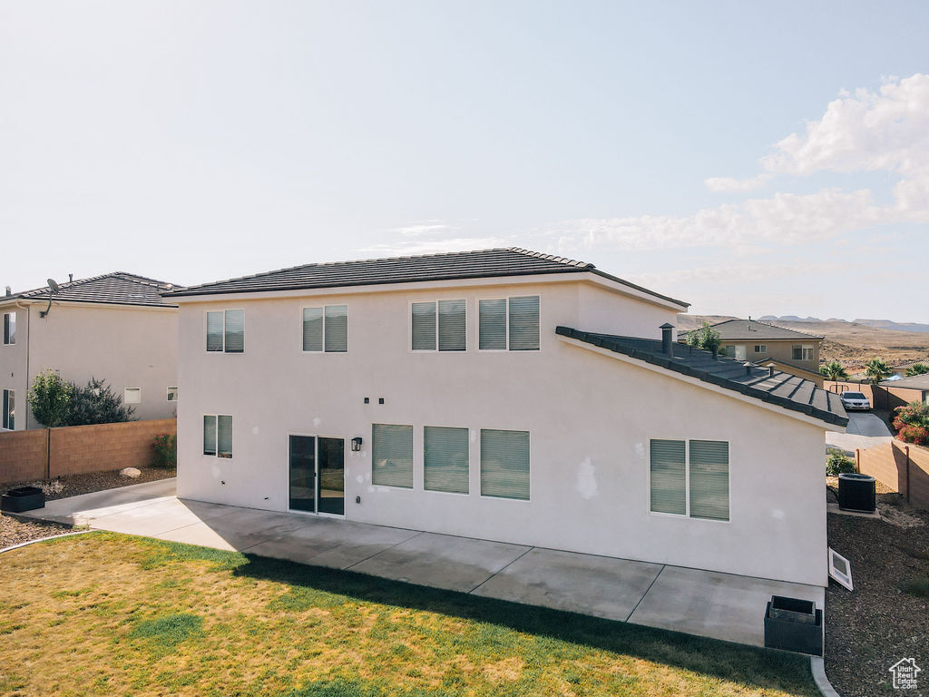 Rear view of house featuring a patio, a tile roof, stucco siding, and central air condition unit