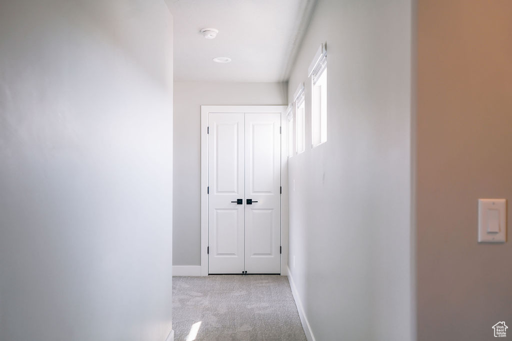 Corridor featuring carpet flooring and baseboards