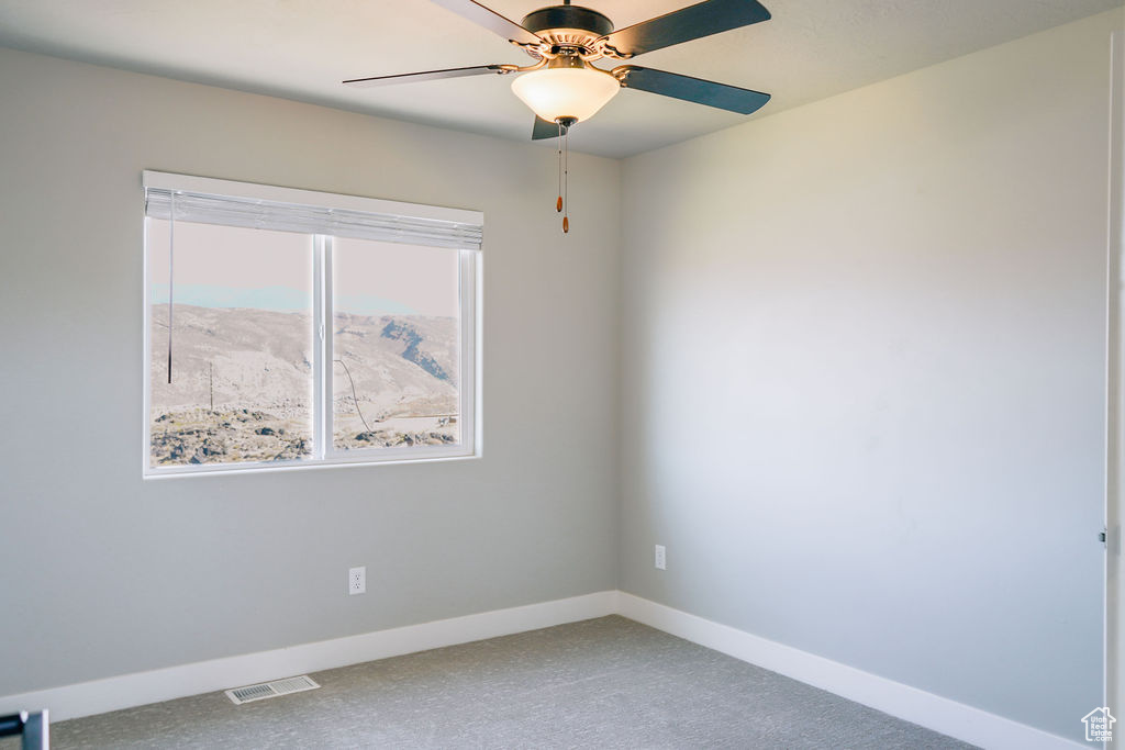Unfurnished room featuring ceiling fan, baseboards, and carpet floors