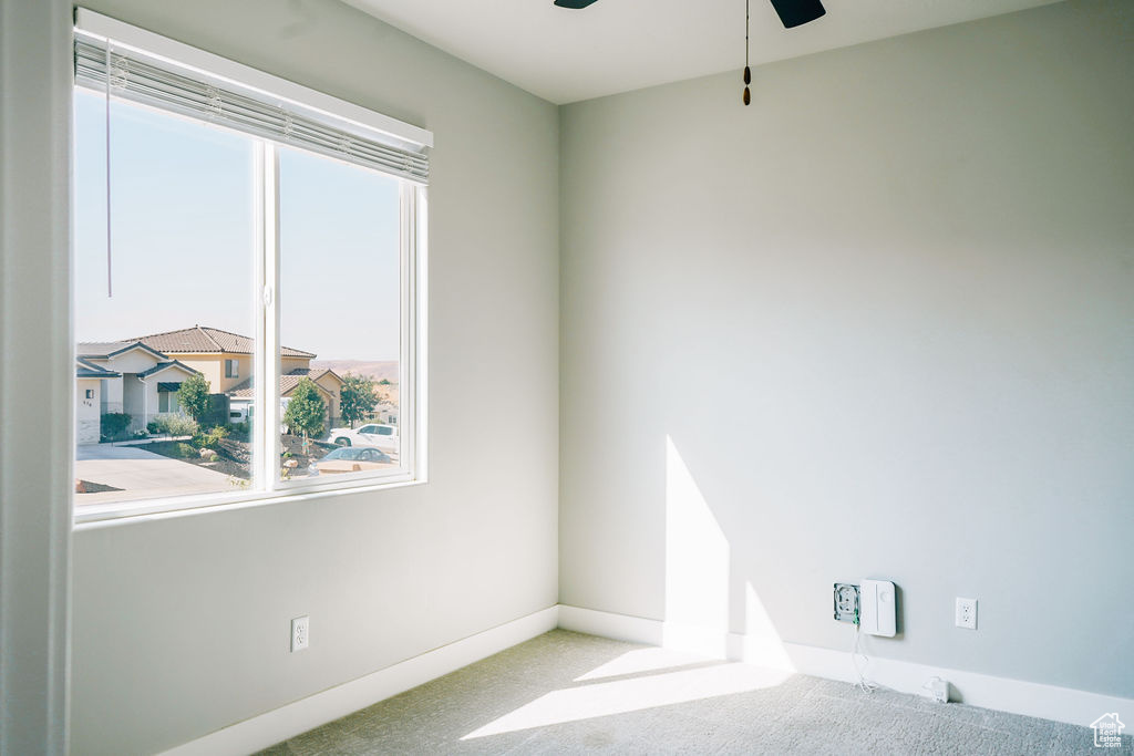 Unfurnished room with a ceiling fan, carpet, and baseboards
