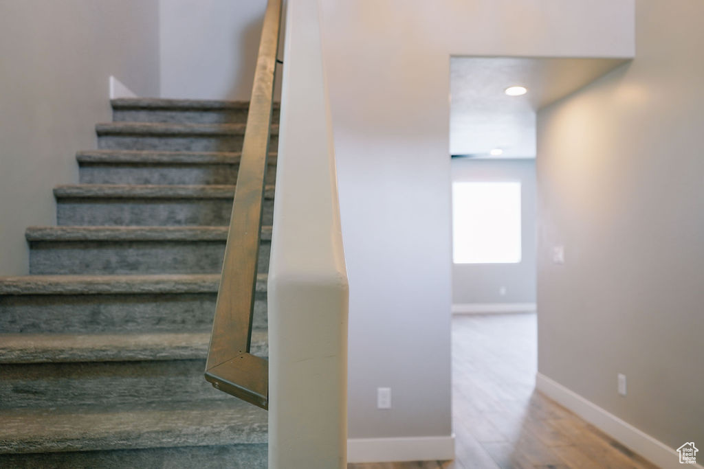 Stairway featuring baseboards and wood finished floors