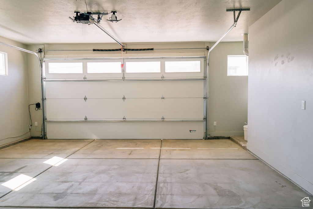 Garage with a garage door opener and baseboards