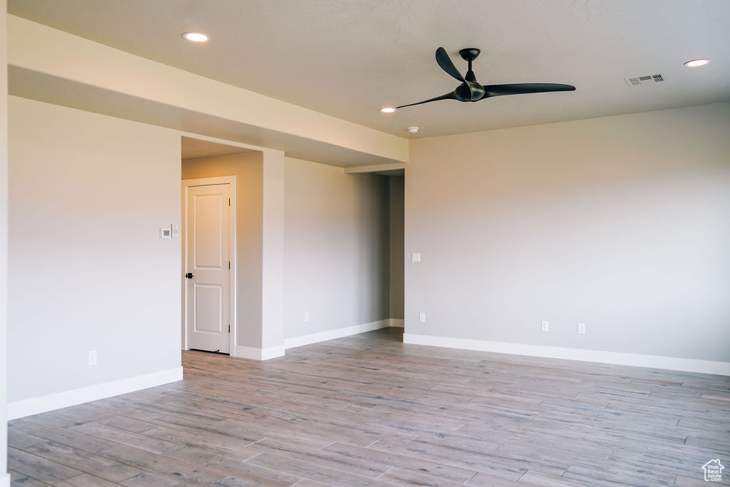 Empty room featuring ceiling fan, light wood-style floors, baseboards, and recessed lighting