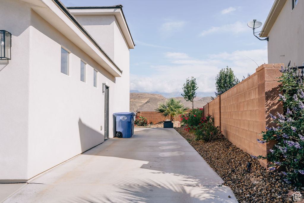 View of side of home with a fenced backyard, stucco siding, and a patio