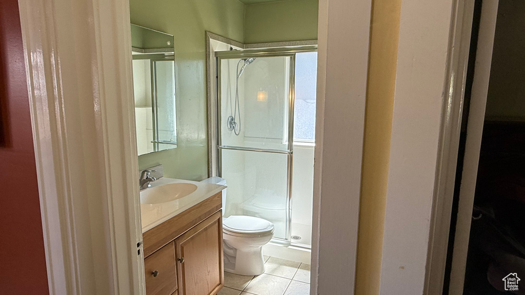 Bathroom featuring toilet, a shower stall, vanity, and tile patterned flooring