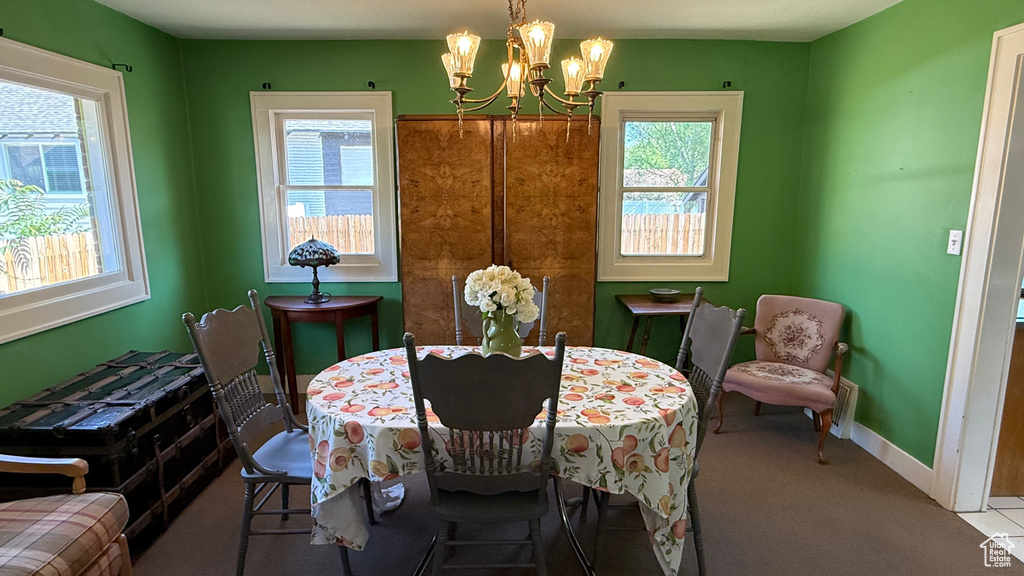 Dining space with a chandelier, carpet floors, and baseboards