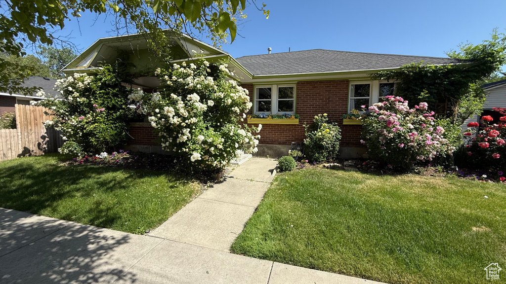 View of front facade with brick siding and roof with shingles