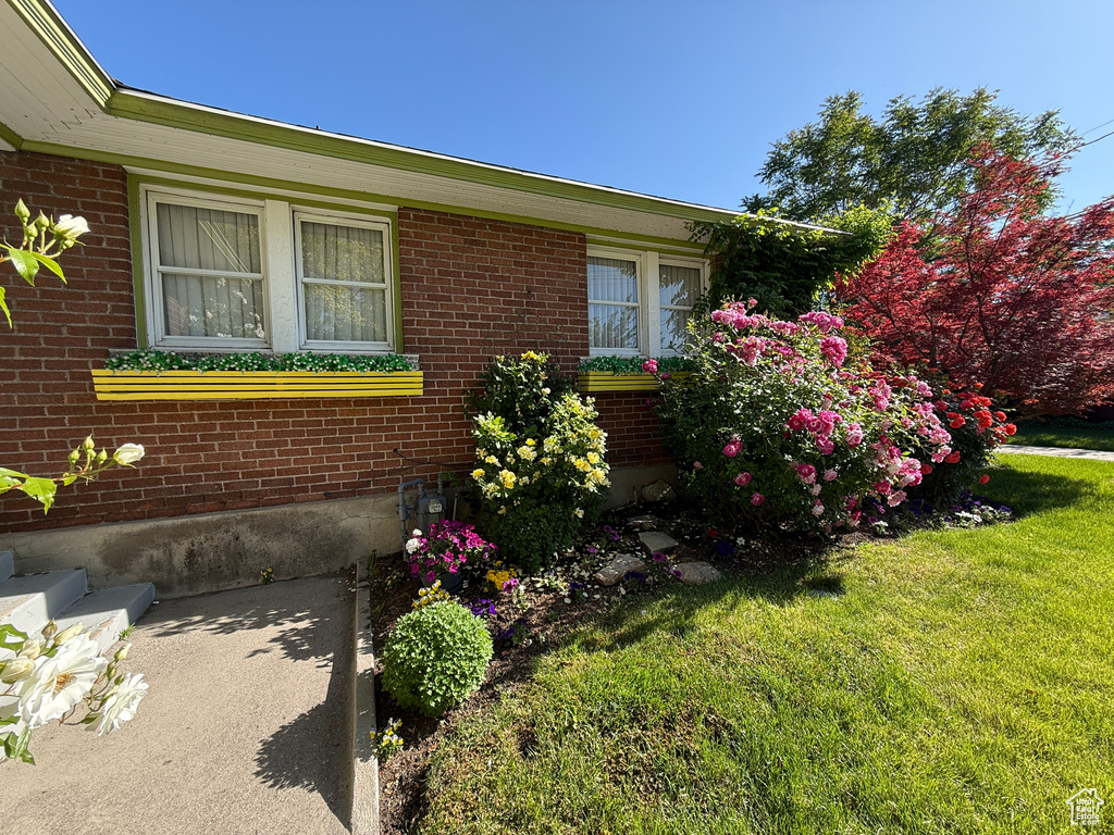 View of home\\\\\\\'s exterior with a lawn and brick siding