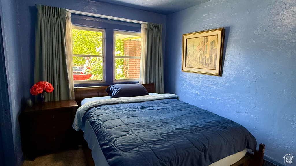 Carpeted bedroom featuring a textured wall