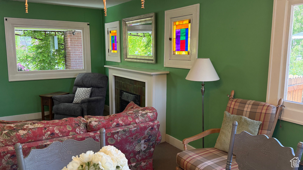 Living room with plenty of natural light, a tile fireplace, and baseboards