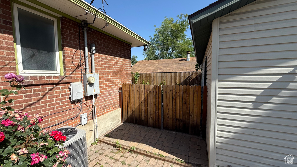 View of side of property featuring central AC unit and brick siding