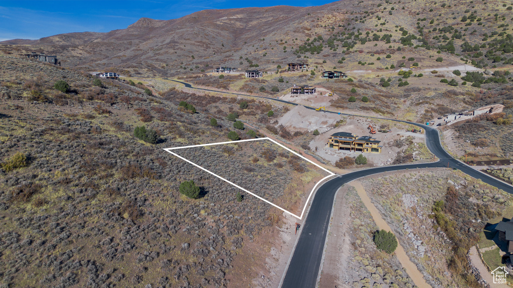 Aerial view of property's location with property boundaries highlighted and a mountainous background