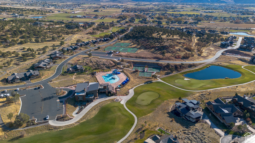 Aerial view of property and surrounding area featuring a water and mountain view and a golf club