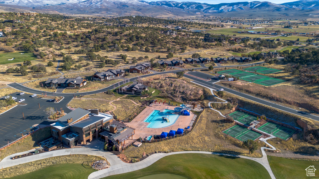 Aerial view of residential area featuring a mountain backdrop and a golf course
