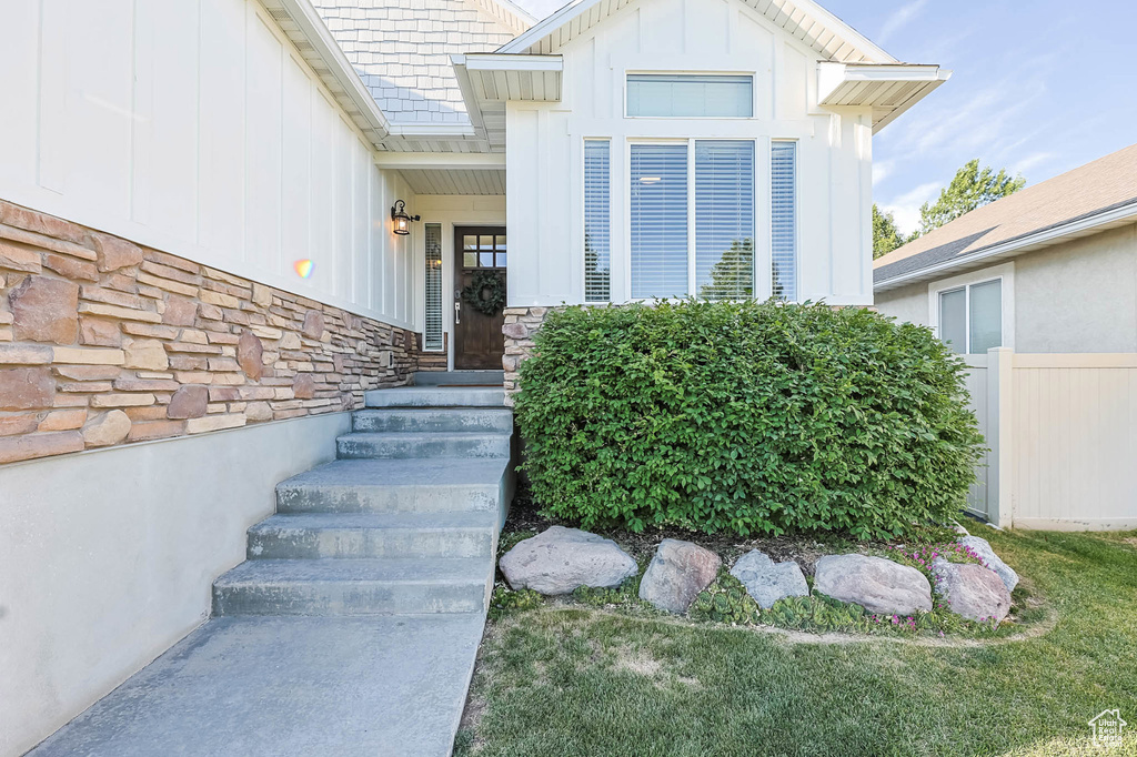 Property entrance featuring board and batten siding and stone siding