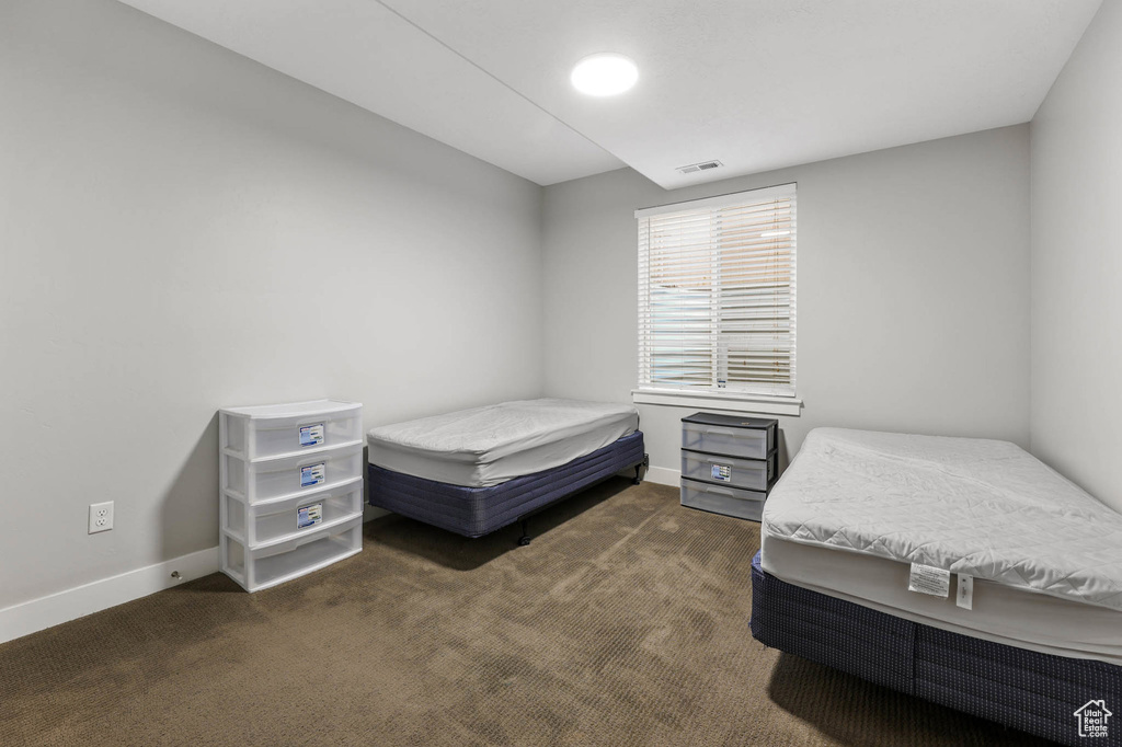 Bedroom featuring dark colored carpet and baseboards