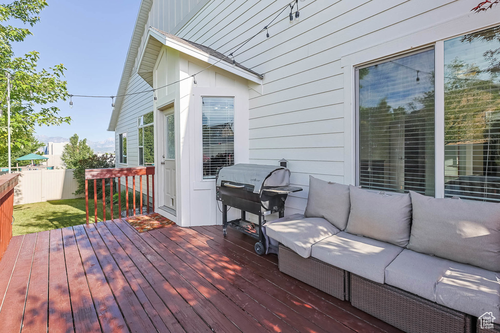 Deck with a grill and an outdoor living space
