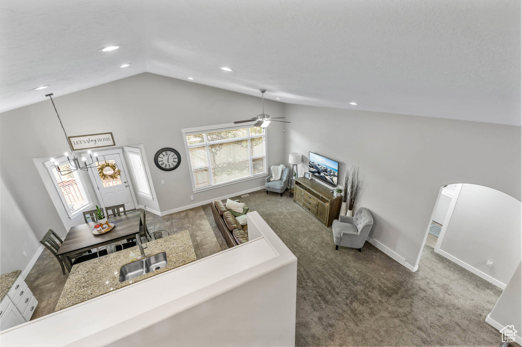 Living area with baseboards, carpet floors, arched walkways, a chandelier, and recessed lighting