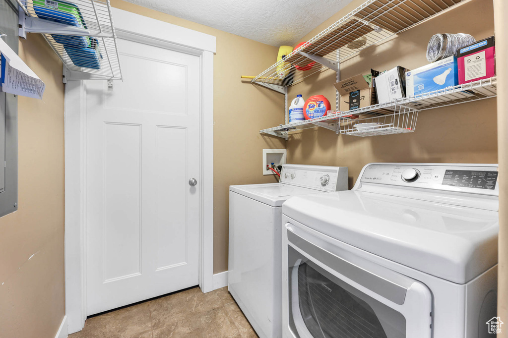 Washroom with washing machine and clothes dryer and baseboards