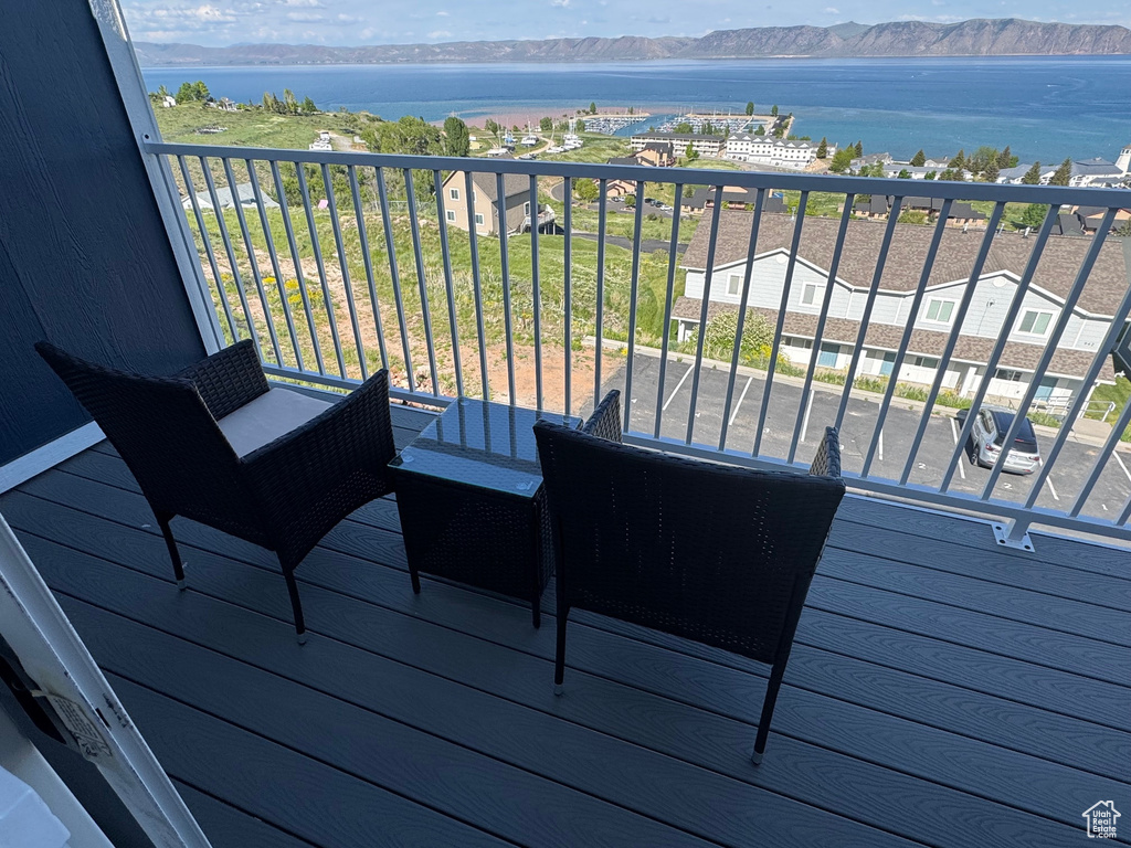 Wooden terrace featuring a water and mountain view