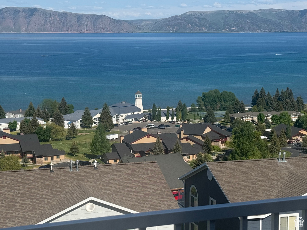 Water view featuring a mountainous background and nearby suburban area