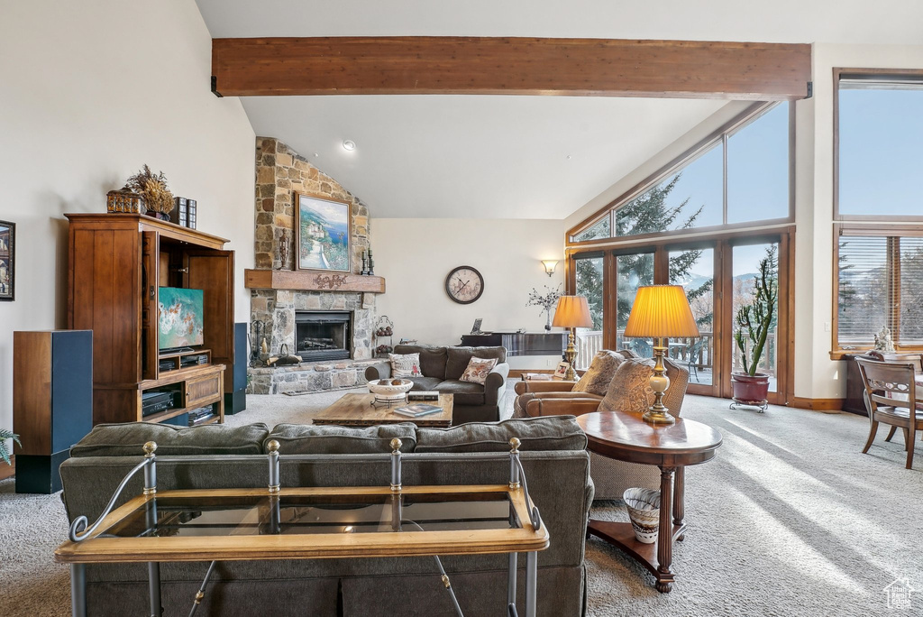Living area with carpet floors, healthy amount of natural light, beamed ceiling, a fireplace, and baseboards