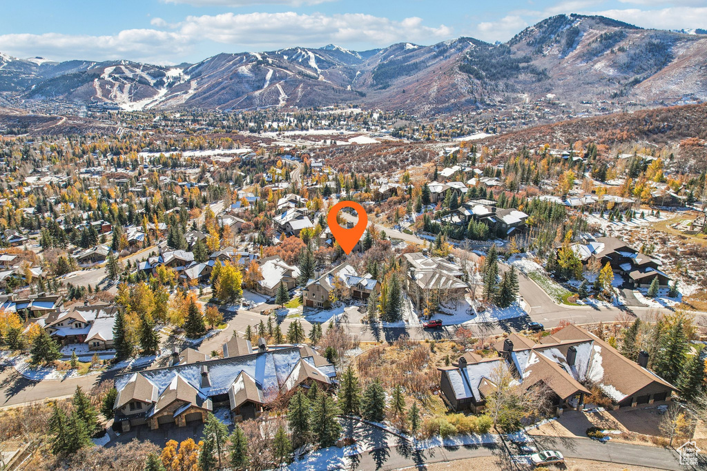 Aerial view of property and surrounding area with mountains and nearby suburban area