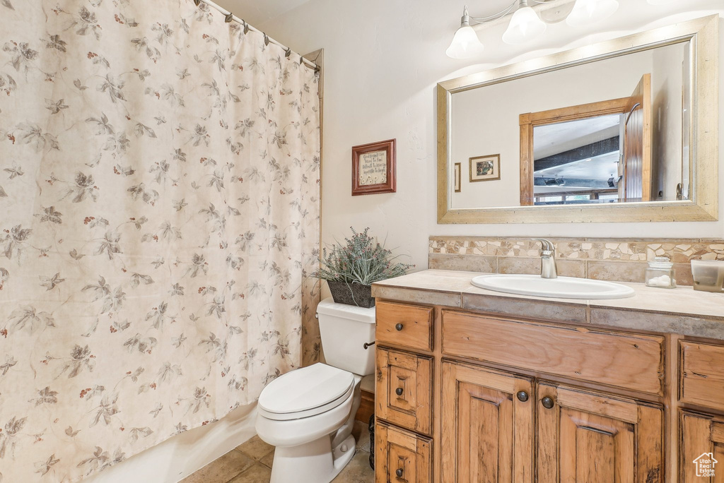 Full bath featuring vanity, toilet, tile patterned flooring, and a shower with shower curtain