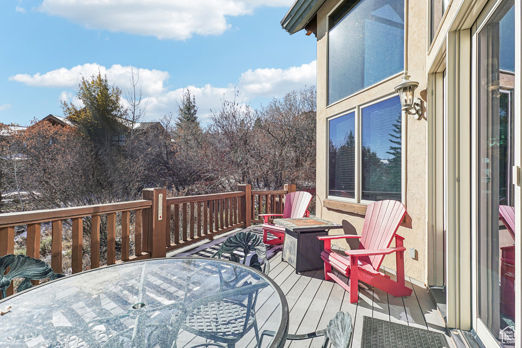 Wooden terrace with outdoor dining space and a fire pit