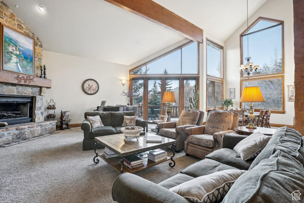 Living room featuring high vaulted ceiling, carpet, a chandelier, a fireplace, and baseboards