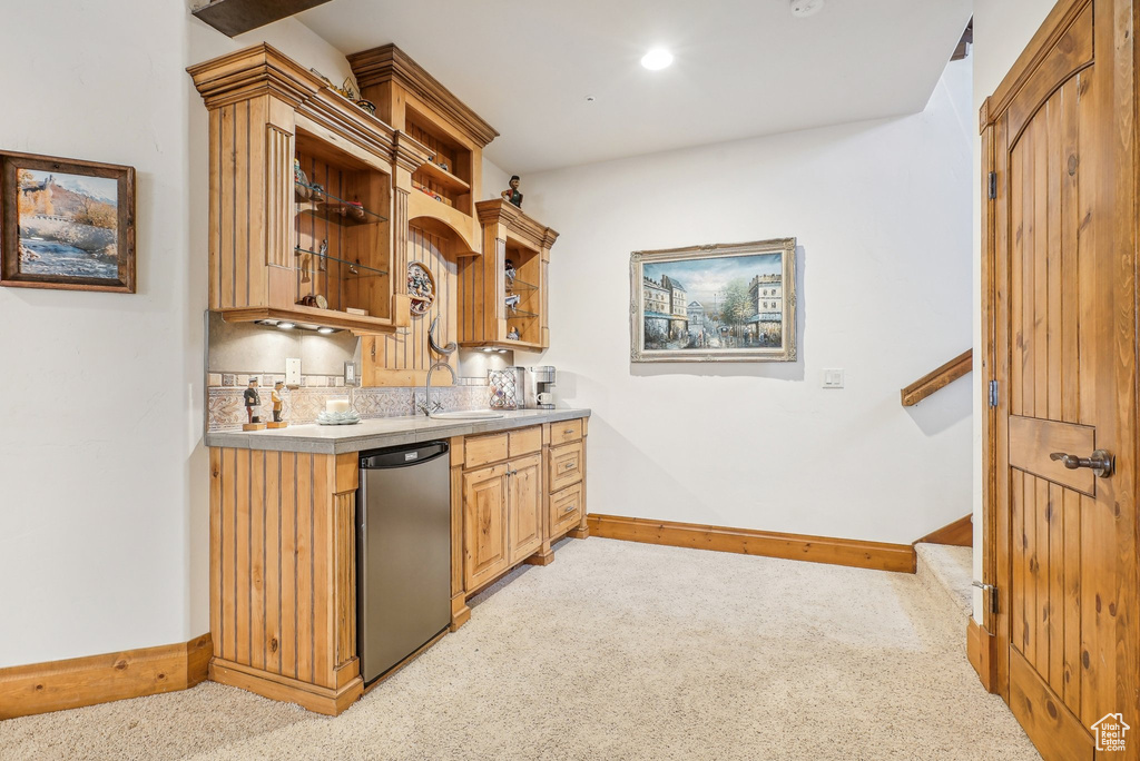 Indoor wet bar with refrigerator, light carpet, baseboards, and recessed lighting