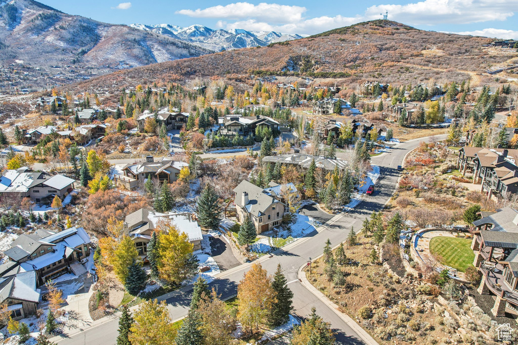 Aerial view of property and surrounding area featuring mountains and nearby suburban area