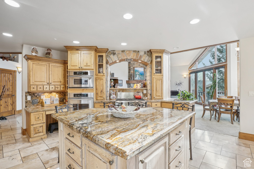 Kitchen with glass insert cabinets, recessed lighting, light stone countertops, and baseboards
