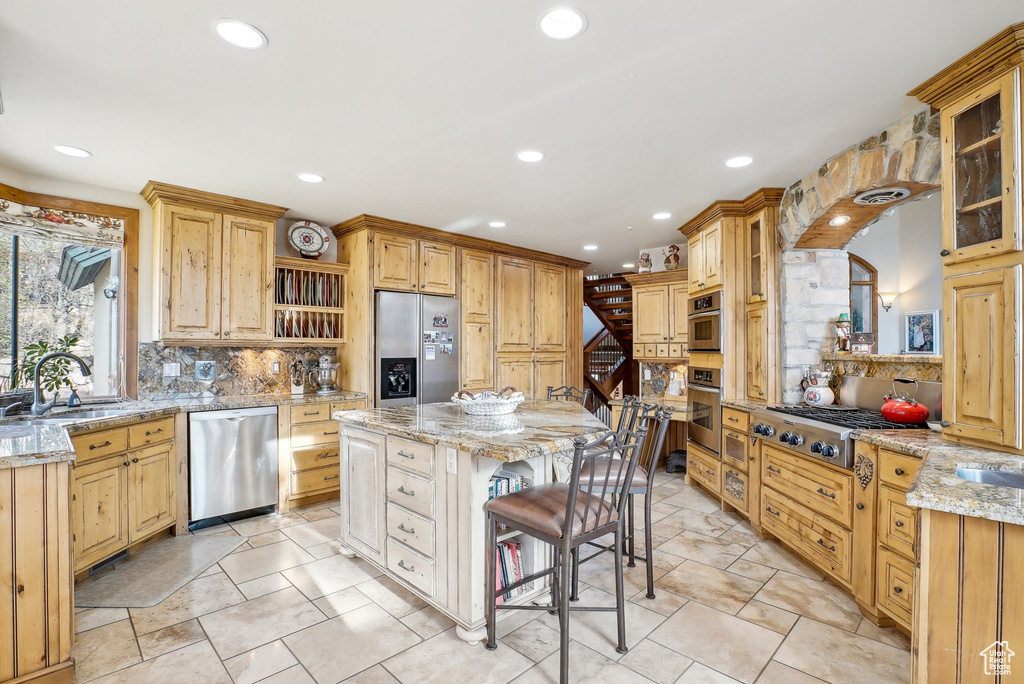 Kitchen featuring appliances with stainless steel finishes, a sink, open shelves, a center island, and recessed lighting