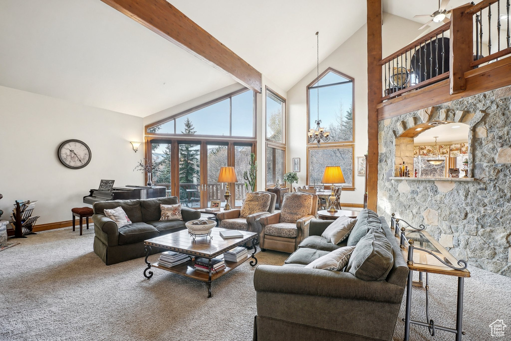 Living area featuring high vaulted ceiling, beam ceiling, carpet, baseboards, and ceiling fan