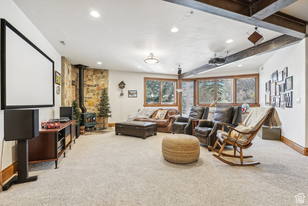 Carpeted cinema room featuring a wood stove, recessed lighting, and baseboards