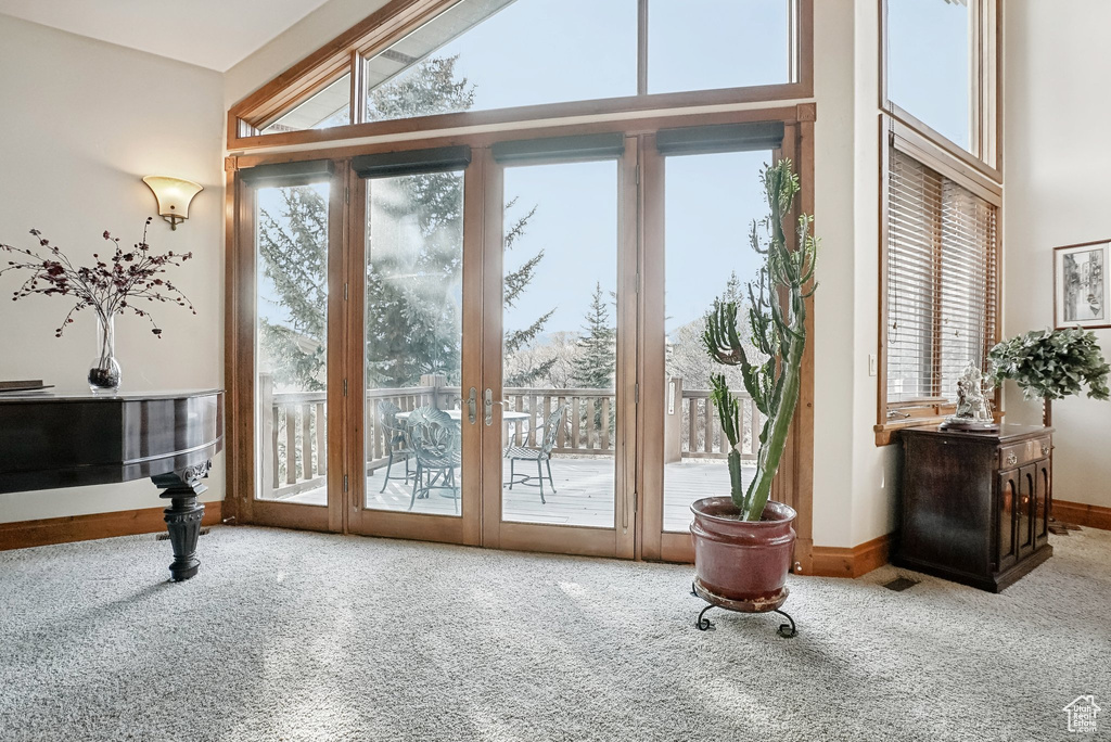 Doorway featuring carpet flooring, baseboards, a high ceiling, and french doors
