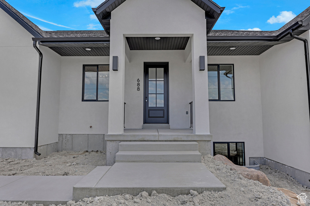 Doorway to property featuring stucco siding