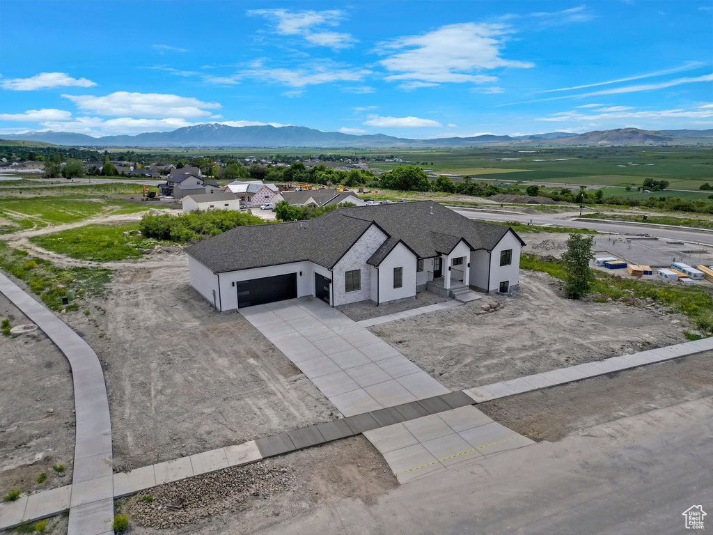 Aerial view of property and surrounding area featuring a mountain backdrop