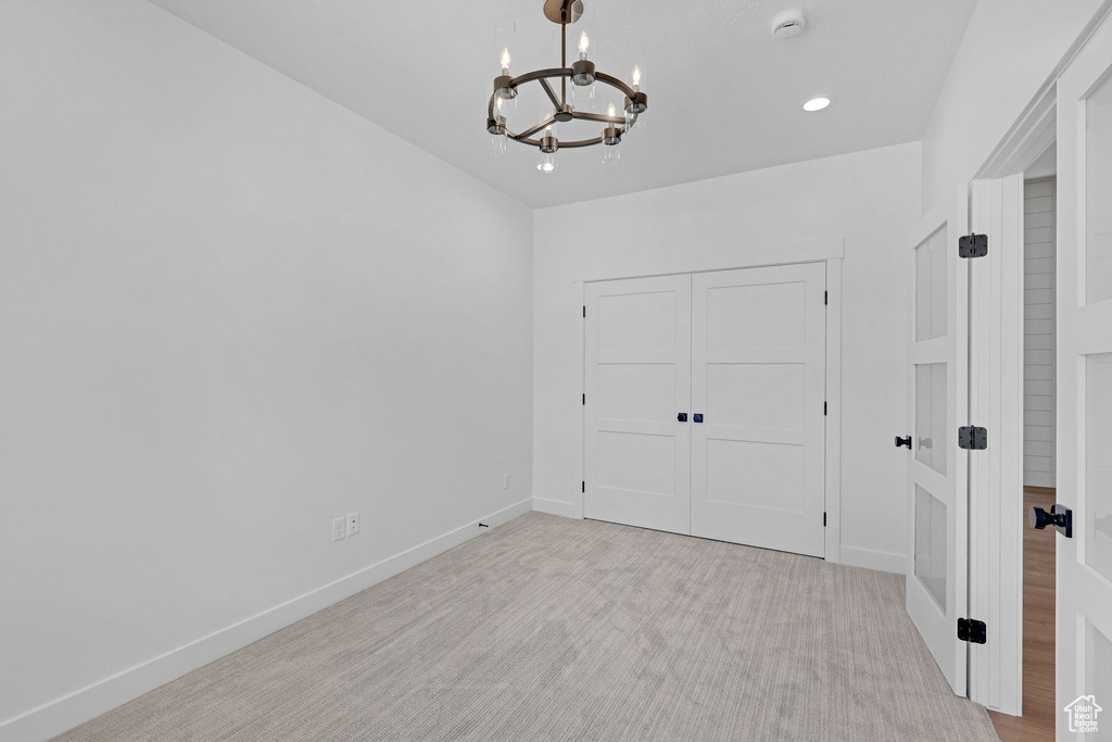 Unfurnished bedroom with a chandelier, baseboards, a closet, and recessed lighting