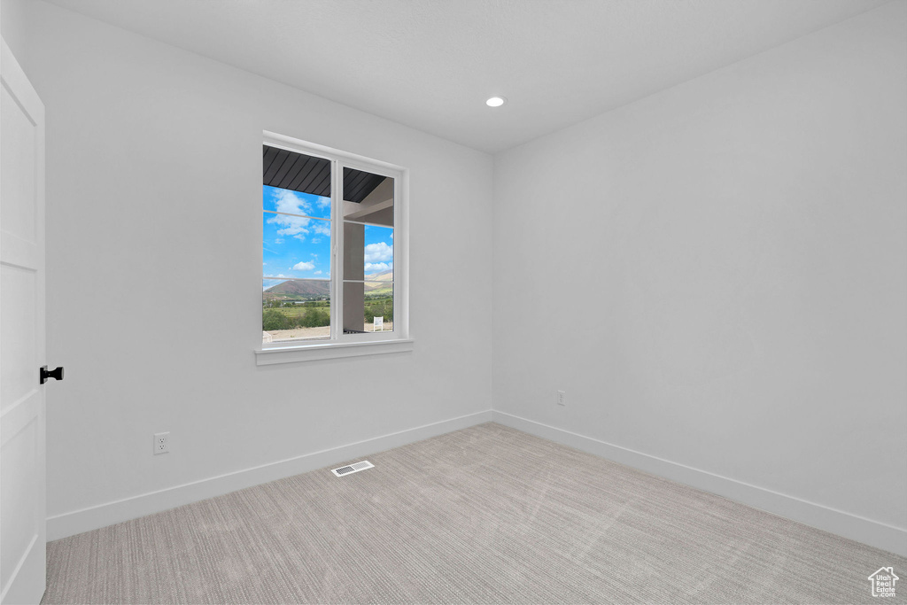 Spare room featuring carpet, baseboards, and recessed lighting