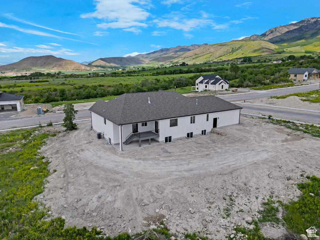 Aerial view of property and surrounding area with a mountain backdrop