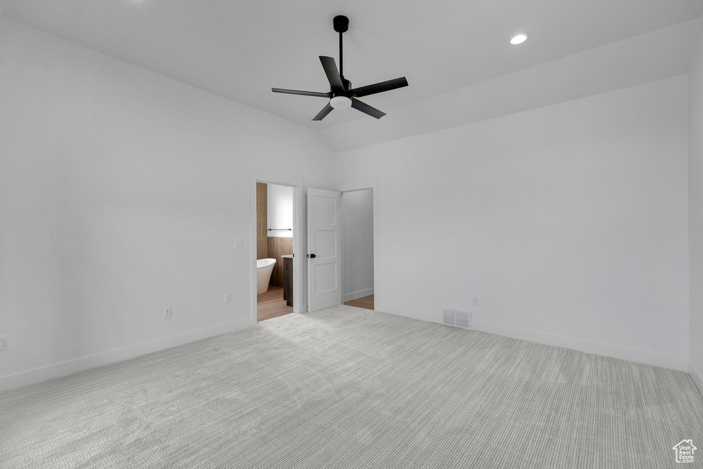 Unfurnished bedroom featuring carpet floors, lofted ceiling, recessed lighting, baseboards, and ensuite bathroom
