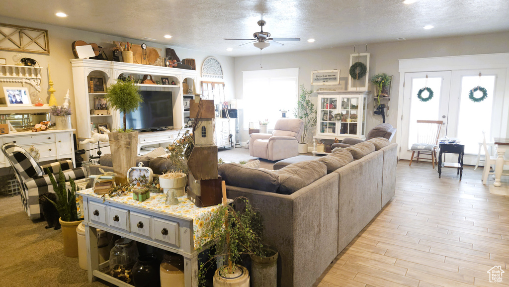 Living area featuring a ceiling fan, plenty of natural light, light wood-type flooring, and recessed lighting