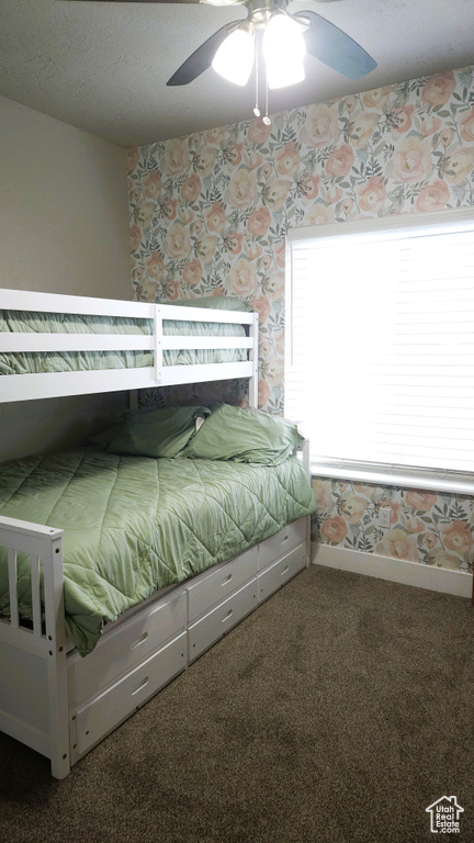 Bedroom featuring carpet flooring, wallpapered walls, a ceiling fan, and baseboards