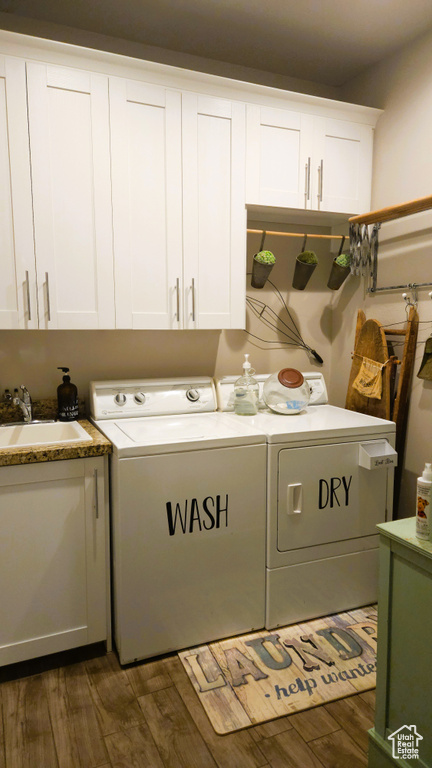 Laundry area with cabinet space, washing machine and dryer, and dark wood-type flooring
