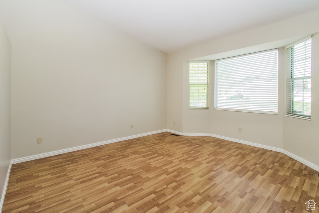 Unfurnished room with light wood-style floors and baseboards