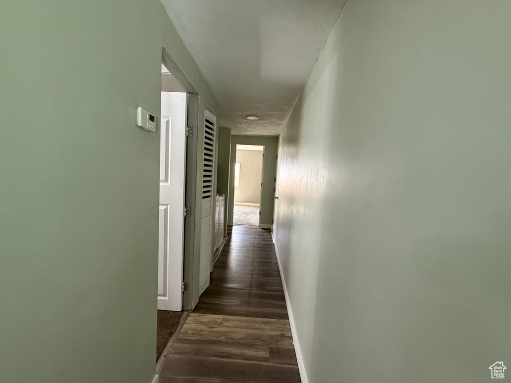Corridor with baseboards and dark wood-style floors