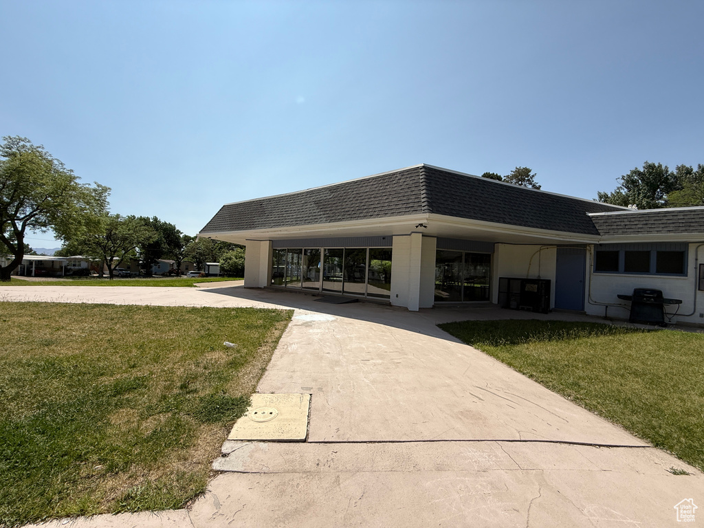 Surrounding community with driveway, a lawn, and a carport